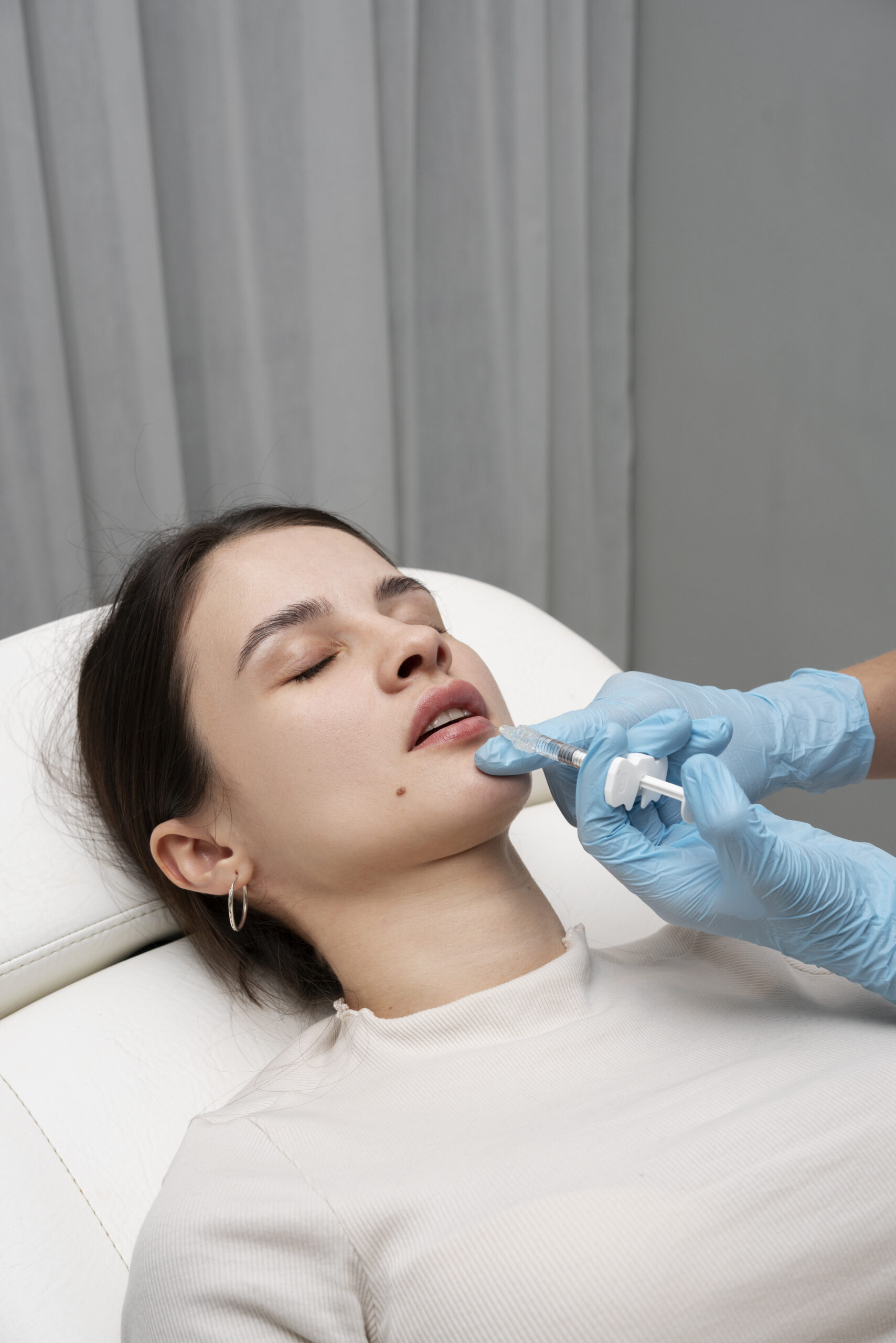 high-angle-woman-getting-lip-fillers-clinic
